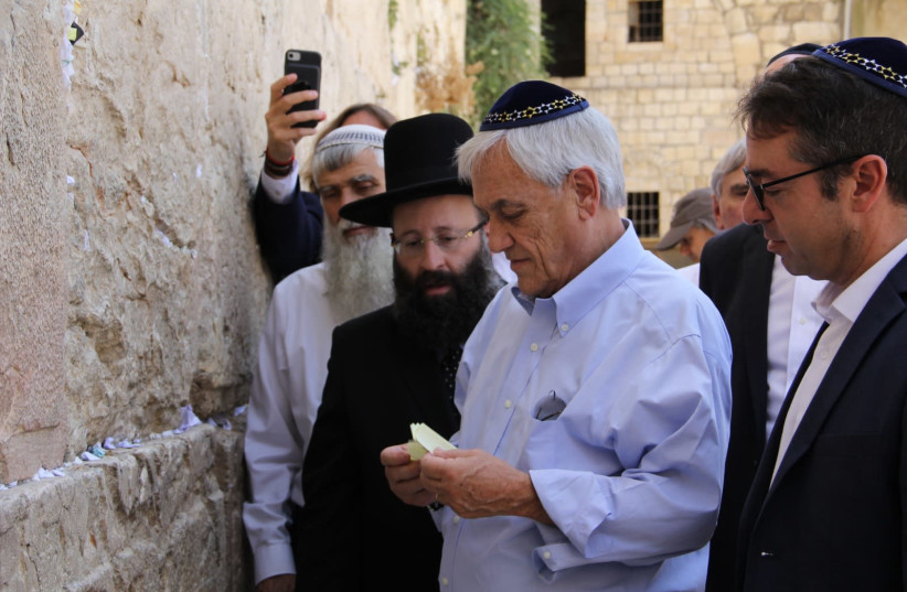 Chile's President Sebastian Pinera places notes from the Anne Frank school in Santiago into the Western Wall (photo credit: WESTERN WALL HERITAGE FOUNDATION)