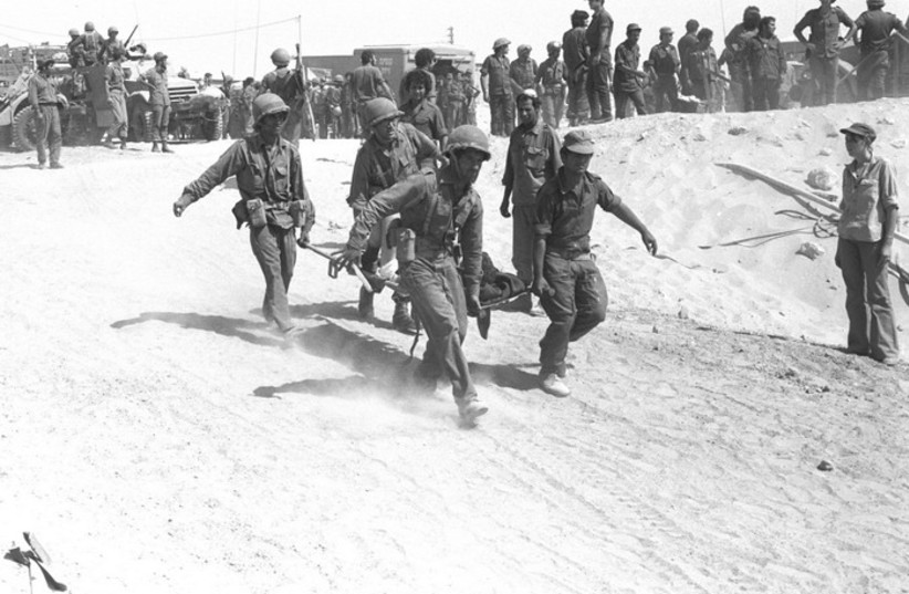  IDF medical crew evacuating an injured soldier from the battle field during Yom Kippur War (credit: IDF FLICKR)