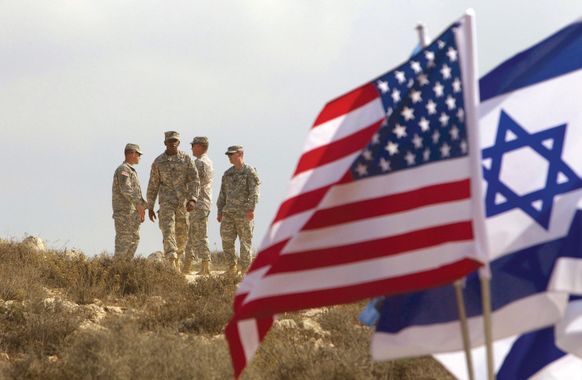 US SOLDIERS stand in the background next to Israeli and American flags during an exercise in Israel. (credit: REUTERS)