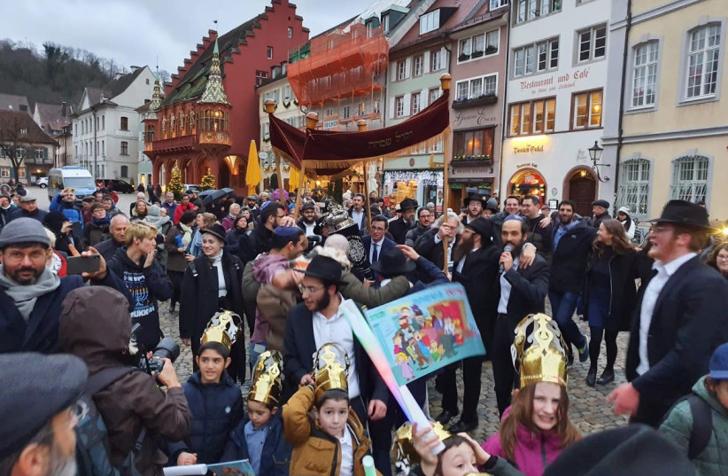 Jews in the German city of Freiburg dance down a street that was once Adolf Hiter Street with a new Torah. (credit: CHABAD OF FREIBURG)