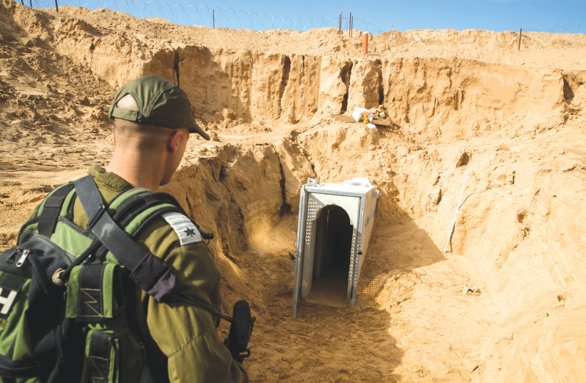 AN IDF SOLDIER stands next to an entrance to a cross-border attack tunnel dug from Gaza to Israel, near Kissufim last year.  (photo credit: JACK GUEZ)