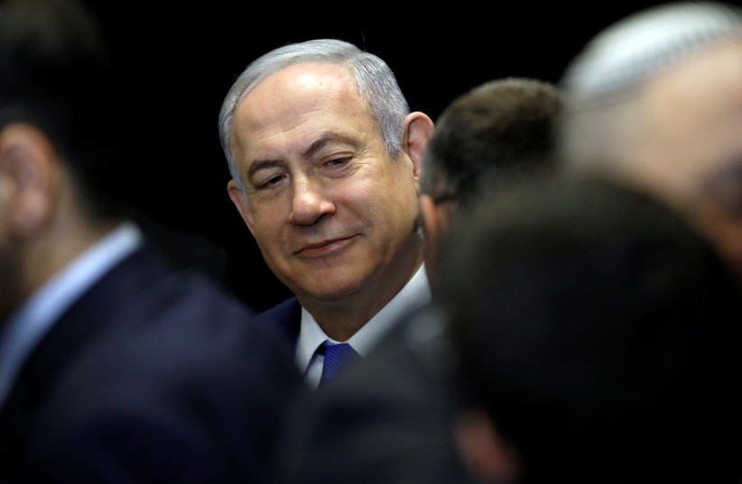 Israeli Prime Minister Benjamin Netanyahu chats with his party's members in Airport City near Tel Aviv, Israel December 27, 2019. (photo credit: AMIR COHEN/REUTERS)