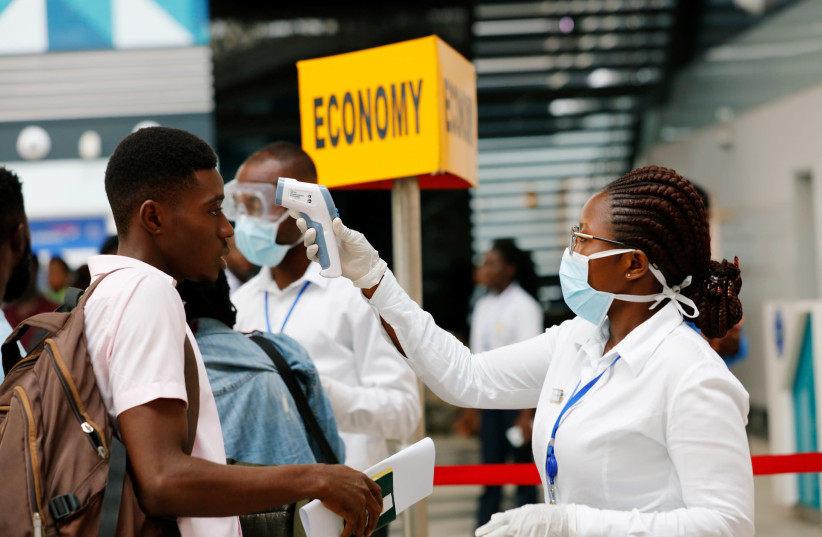 A health worker checks the temperature of a traveller as part of the coronavirus screening procedure at the Kotoka International Airport in Accra, Ghana January 30, 2020.  (photo credit: REUTERS/FRANCIS KOKOROKO)