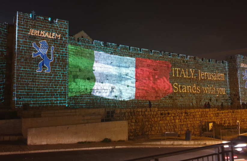 The Italian flag shown on the Old City walls of Jerusalem to show solidarity during the coronavirus outbreak (credit: ARNON BOSSANI)