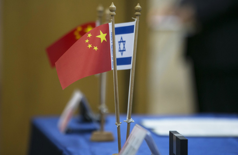 Chinese and Israeli flags are seen on a table during a signing ceremony in Tel Aviv, 2014 (photo credit: BAZ RATNER/REUTERS)