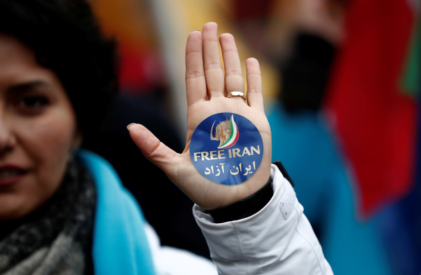A woman displays a "Free Iran" sticker as thousands of Iranian opponents in exile stage a protest against the Teheran regime. Paris, France, February 8, 2019 (photo credit: BENOIT TESSIER/REUTERS)