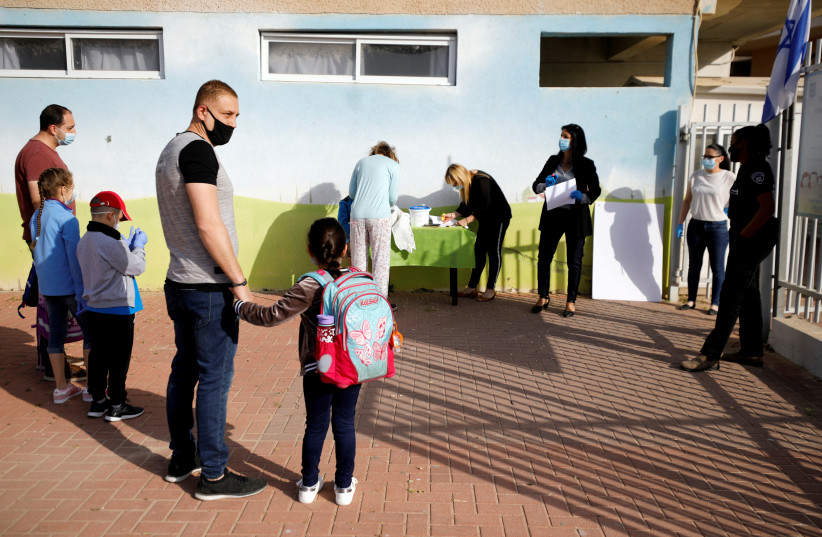 FILE PHOTO: Parents wait with their children to enter their elementary school in Sderot as it reopens following the ease of restrictions preventing the spread of the coronavirus disease (COVID-19) in Israel May 3, 2020 (credit: REUTERS/AMIR COHEN/FILE PHOTO)
