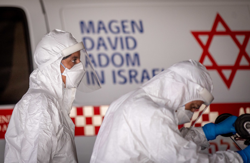 Magen David Adom workers wearing protective clothing seen outside the coronavirus unit at Shaare Zedek Medical Center, Jerusalem, September 6, 2020 (photo credit: YONATAN SINDEL/FLASH90)