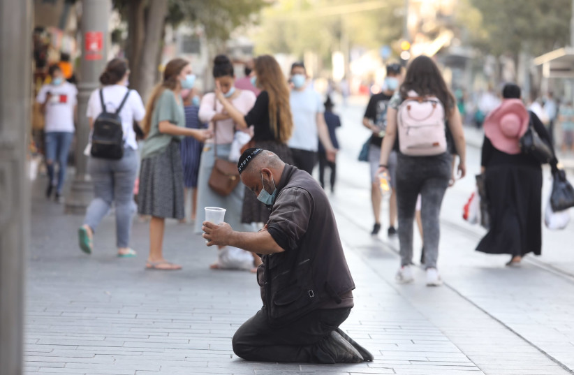 A beggar sits and asks for money amid the coronavirus crisis, Jerusalem, 2020 (credit: MARC ISRAEL SELLEM)