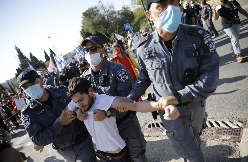 Israeli police officers detain a demonstrator during a protest against Israeli prime minister Benjamin Netanyahu, outside the Israeli parliament in Jerusalem on September 29, 2020. (credit: OLIVIER FITOUSSI/FLASH90)