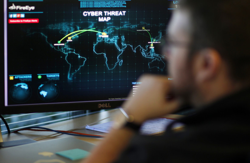 An information analyst works in front of a screen showing a near real-time map tracking cyber threats; California, December 29, 2014 (credit: REUTERS/BECK DIEFENBACH)