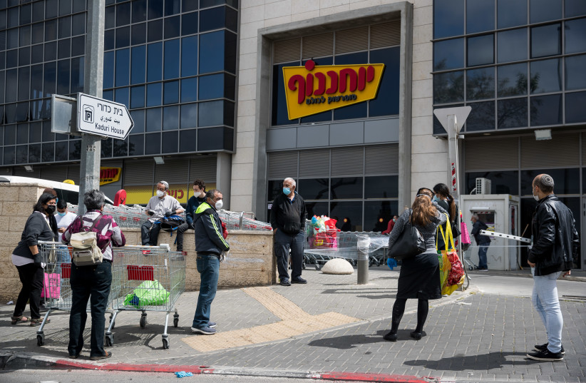 People waiting in line outside Yochananof supermarket in Jerusalem on April 7, 2020. The government ordered on a partial lockdown, in order to prevent the spread of the coronavirus. (credit: YONATAN SINDEL/FLASH 90)