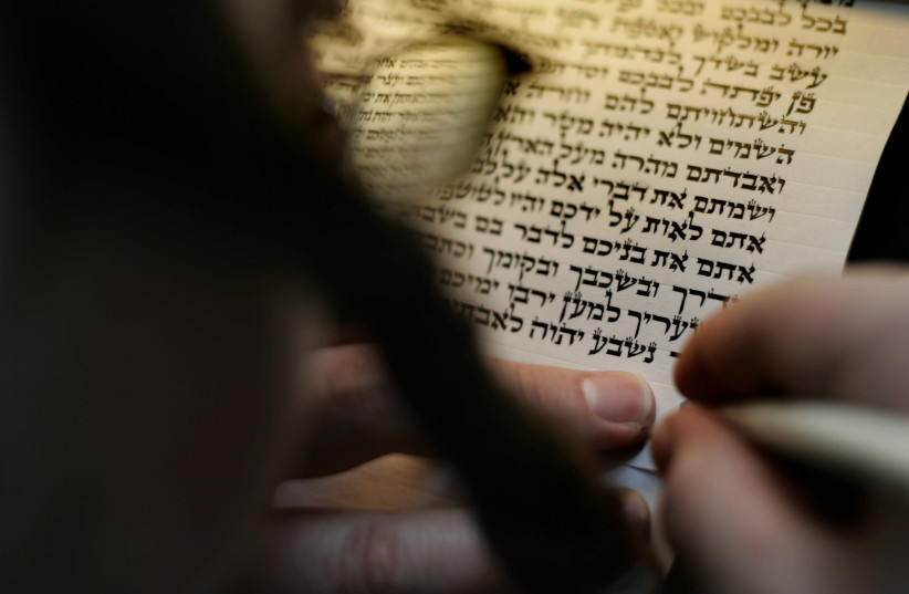A sofer writes verses from the Shema prayer on a 'klaf' with a quill pen (credit: OLIVIER FITOUSSI/FLASH90)