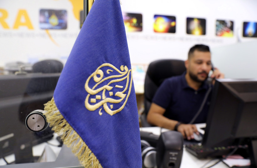 An employee works inside the office of the Qatar-based Al-Jazeera network in Jerusalem (credit: REUTERS)