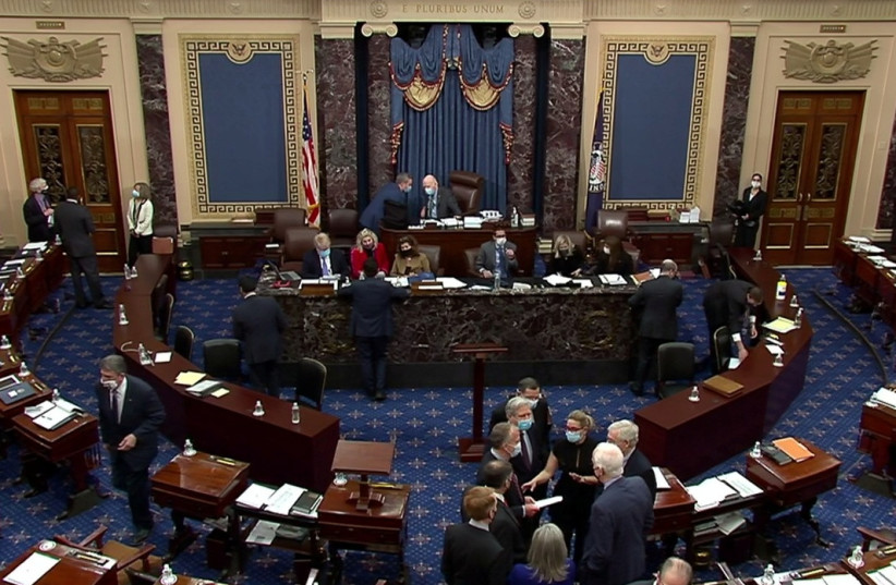 US Senate Minority Leader Mitch McConnell (R-KY) huddles on the Senate floor with Senator Kyrsten Sinema (D-AZ), Senator John Barrasso (R-WY), Senator John Hoeven (R-ND), Senator Dan Sullivan (R-AK), Senator James Lankford (R-OK), Senator Joni Ernst (R-IA) and Senator John Cornyn (R-TX) and others (credit: REUTERS)