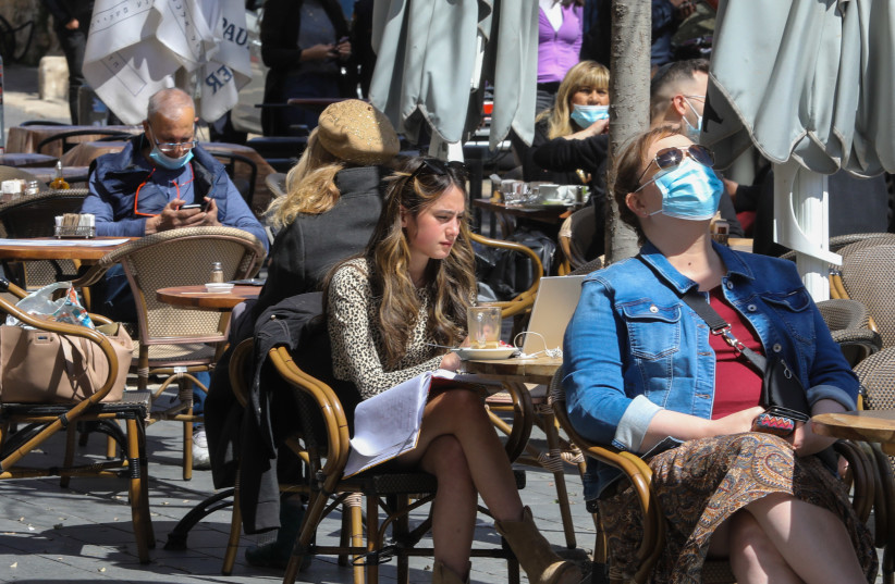 People sit and drink coffee in the sun as Israel reopens its economy after COVID-19 restrictions   (credit: MARC ISRAEL SELLEM)