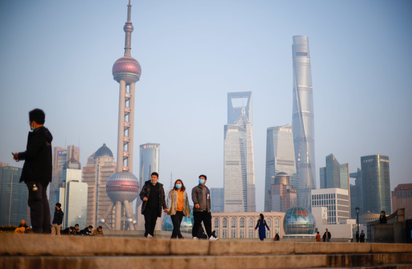 People walk at the Bund, in front of Lujiazui financial district of Pudong, Shanghai (credit: REUTERS/ALY SONG)