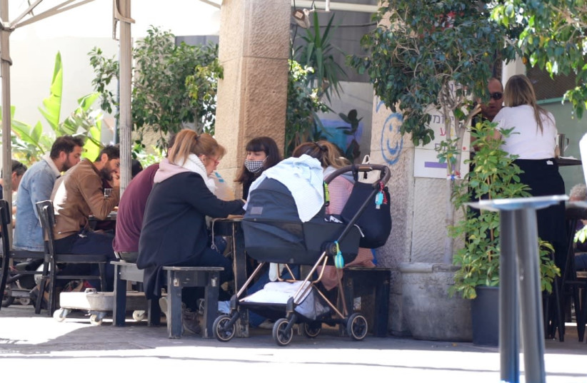 Patrons at a restaurant in Tel Aviv, Israel. March 7, 2021. (photo credit: RAYMOND CRYSTAL/THE MEDIA LINE)