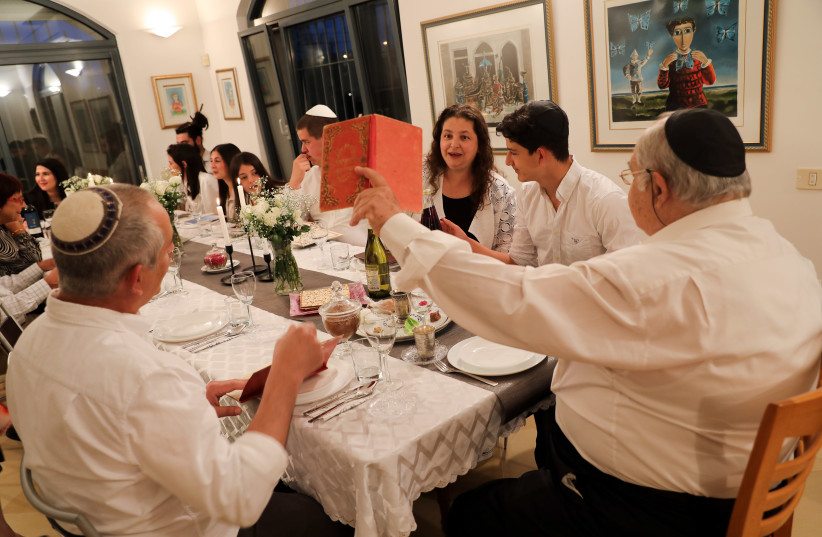 A family seen during the ''passover seder'' on the first night of the 8-day long Jewish holiday of Passover, in Tzur Hadassah, April 8, 2020.
