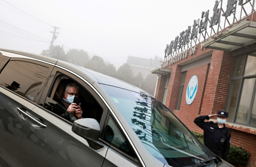 Dominic Dwyer, a member of the World Health Organization (WHO) team tasked with investigating the origins of the coronavirus disease (COVID-19), sits in a car arriving to Wuhan Institute of Virology in Wuhan, Hubei province, China February 3, 2021. (photo credit: REUTERS/THOMAS PETER/FILE PHOTO)