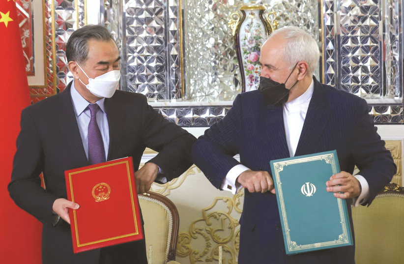 FOREIGN MINISTERS Mohammad Javad Zarif of Iran and Wang Yi of China bump elbows during the signing ceremony of a 25-year cooperation agreement, in Tehran last month. (photo credit: MAJID ASGARIPOUR/WANA/REUTERS)