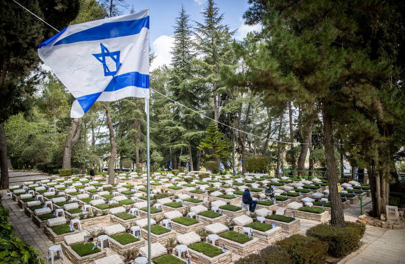 Family members visit the graves of their loved ones at the military cemetery on Mount Herzl in Jerusalem on April 11, 2021 (photo credit: YONATAN SINDEL/FLASH90)