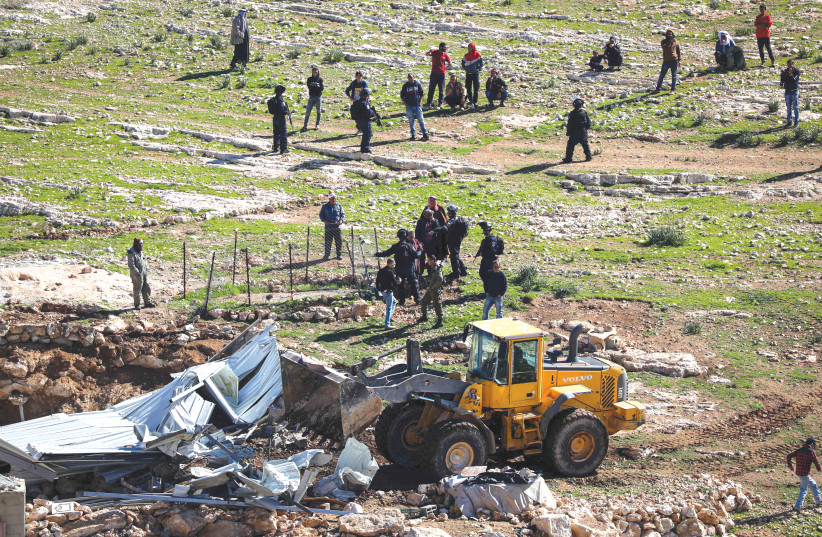 A BULLDOZER is used to demolish a shed in the West Bank village of Masafer in February 2020. (photo credit: WISAM HASHLAMOUN/FLASH90)
