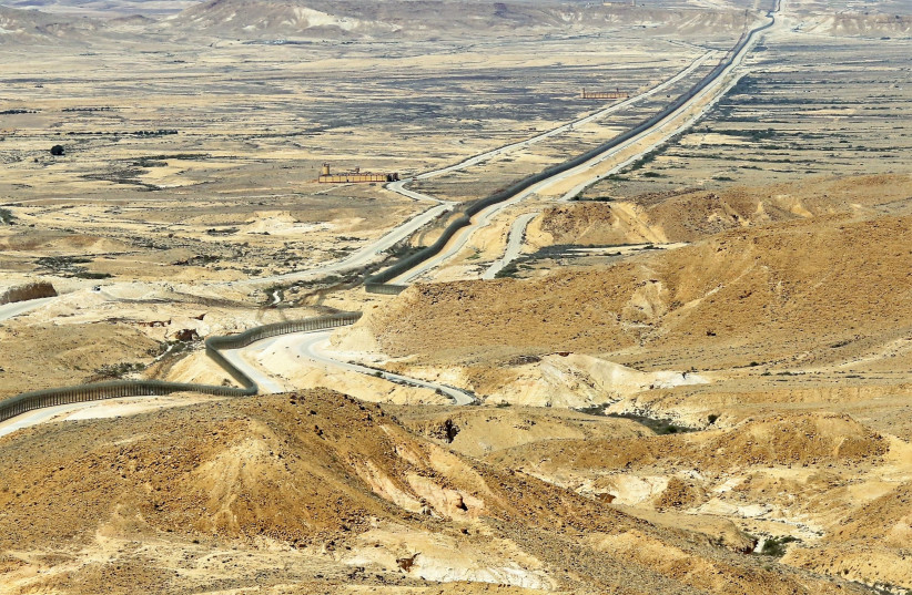 THE BORDER fence cuts across the arid landscape. Looking north, Egypt and the Sinai Desert are to the left of the fence and Israel and the Negev Desert lie on its right. (photo credit: ORI LEWIS)