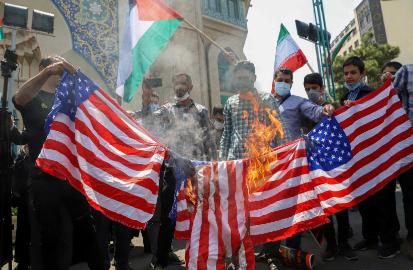 Iranians burn US flags during a protest to express solidarity with the Palestinian people amid a flare-up of Israeli-Palestinian violence, in Tehran, Iran May 18, 2021. (photo credit: MAJID ASGARIPOUR/WANA (WEST ASIA NEWS AGENCY) VIA REUTERS)
