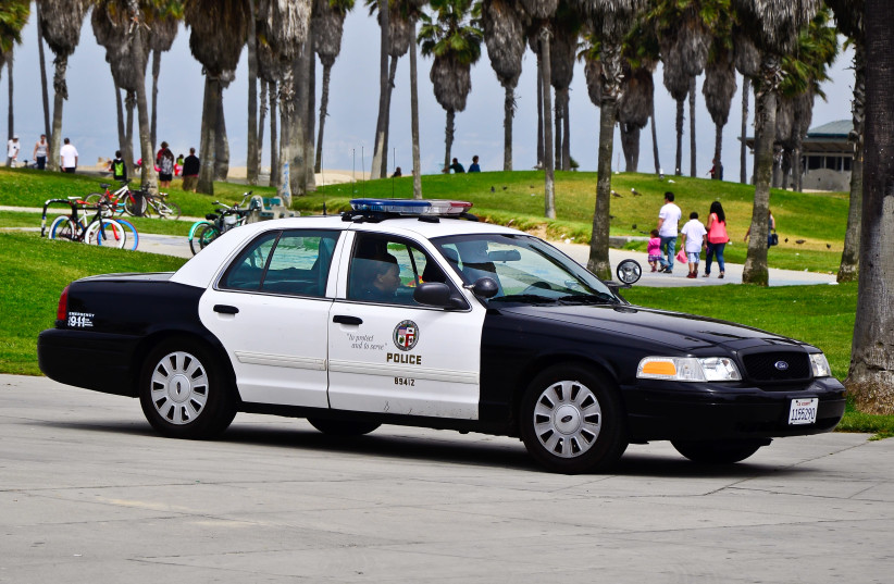 Los Angeles Police Department (LAPD) officers in a car (illustrative). (credit: Wikimedia Commons)