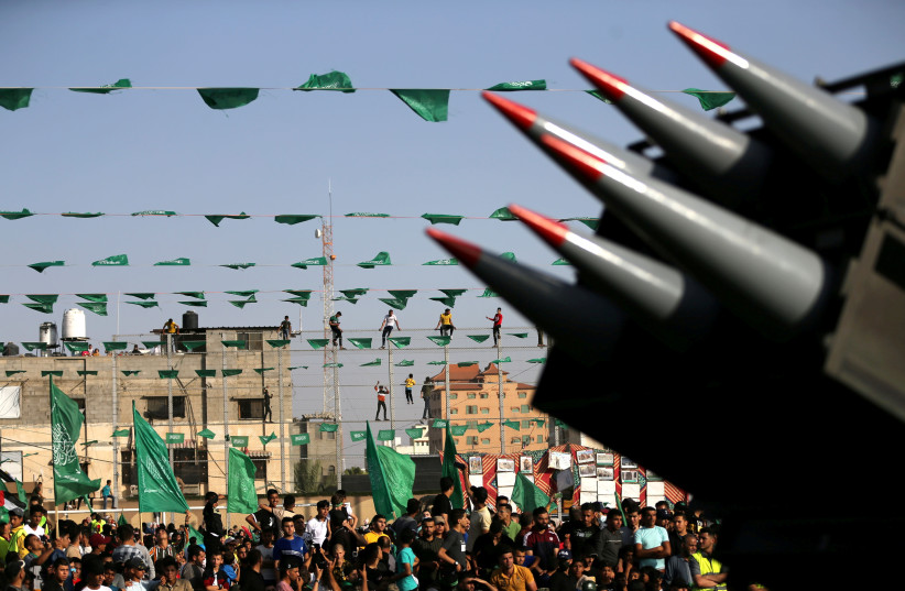 Palestinian Hamas supporters attend an anti-Israel rally as rockets are displayed on a truck by Hamas militants in Rafah, in the southern Gaza Strip May 28, 2021 (credit: REUTERS/IBRAHEEM ABU MUSTAFA)