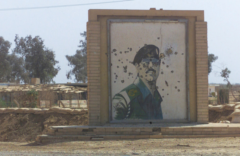 BULLET-RIDDLED mural of Saddam Hussein in southern Iraq, along the road to Baghdad (credit: PICRYL)