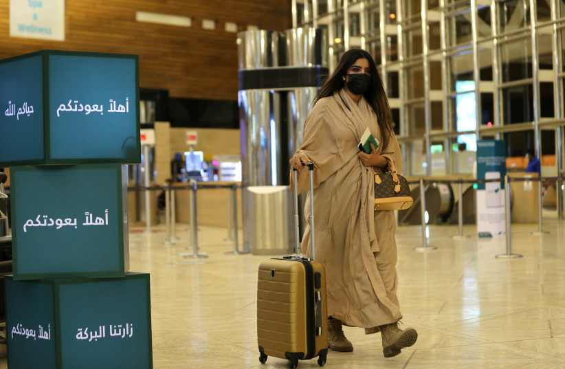 A Saudi woman wearing a facemask walks with her luggage as she arrives at the King Khalid International Airport, after Saudi authorities lift the travel ban on its citizens after fourteen months due to the coronavirus disease (COVID-19) restrictions, in Riyadh, Saudi Arabia, May 16, 2021. (photo credit: REUTERS/AHMED YOSRI)