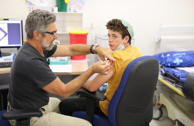 A boy receives a dose of the Pfizer-BioNTech vaccine at Jerusalem’s Misgav Ladach Hospital on June 6, as Israel began its coronavirus vaccination campaign for 12-to-15 year olds (credit: MARC ISRAEL SELLEM)