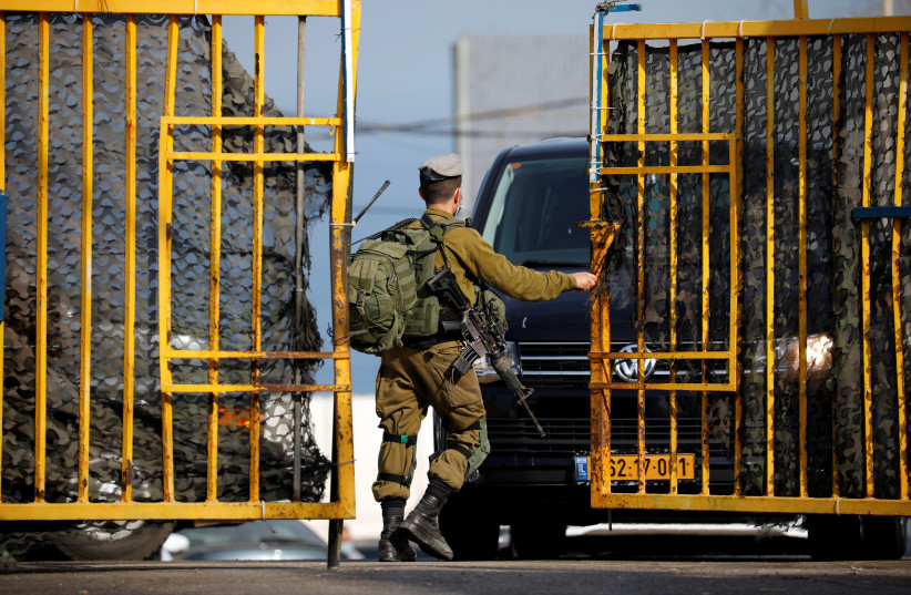 An Israeli soldier opens a gate at a military base leading to the border crossing with Lebanon at Rosh Hanikra, northern Israel (credit: AMIR COHEN/REUTERS)