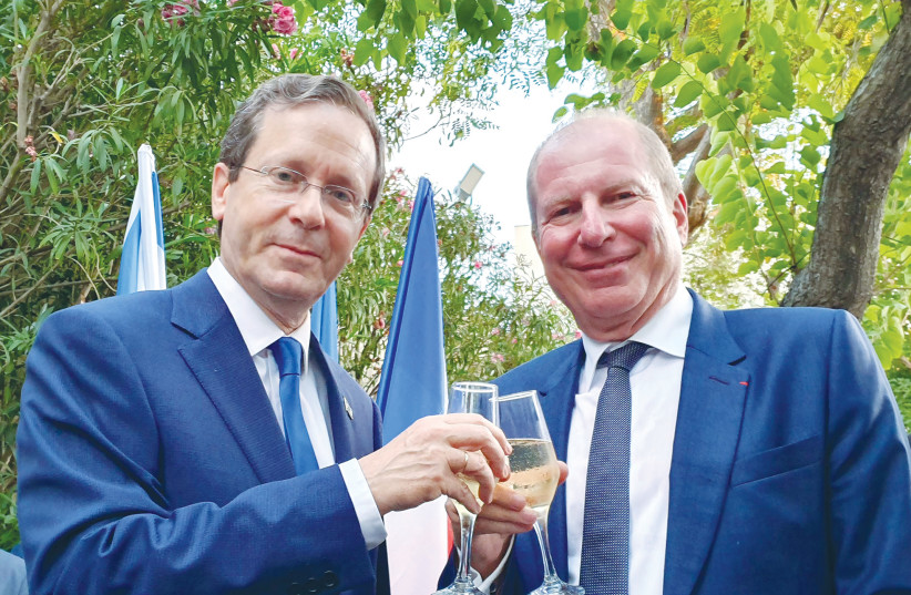 PRESIDENT ISAAC HERZOG and Eric Danon, ambassador of France, clink glasses on Bastille Day. (credit: COURTESY EMBASSY OF FRANCE)