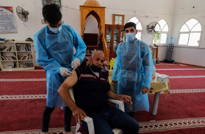 Medical worker inject a shot of the Sputnik V Covid-19 vaccine to worshipers in mosque in Khan Yunis Gaza, on July 06, 2021 (photo credit: ABED RAHIM KHATIB/FLASH90)