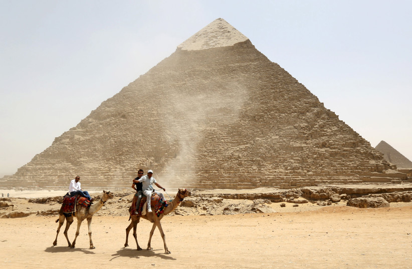  Tourists ride on camels next to Pyramid of Khufu on Great Pyramids of Giza, on the outskirts of Cairo (credit: REUTERS/MOHAMED ABD EL GHANY)