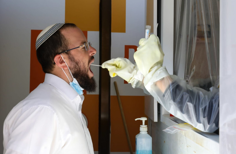 Israeli receiving a COVID test at Meuhedet Health Maintenance Organization center in Jerusalem on August 11, 2021. (credit: MARC ISRAEL SELLEM)