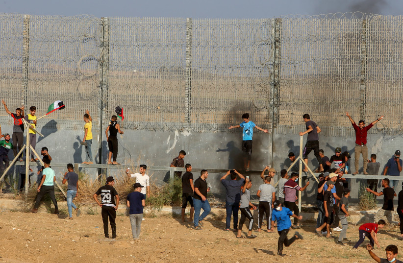  Palestinian protesters clash with Israeli forces during a protest at the Israel-Gaza border, east of Gaza City, on August 21, 2021. (credit: ABED RAHIM KHATIB/FLASH90)