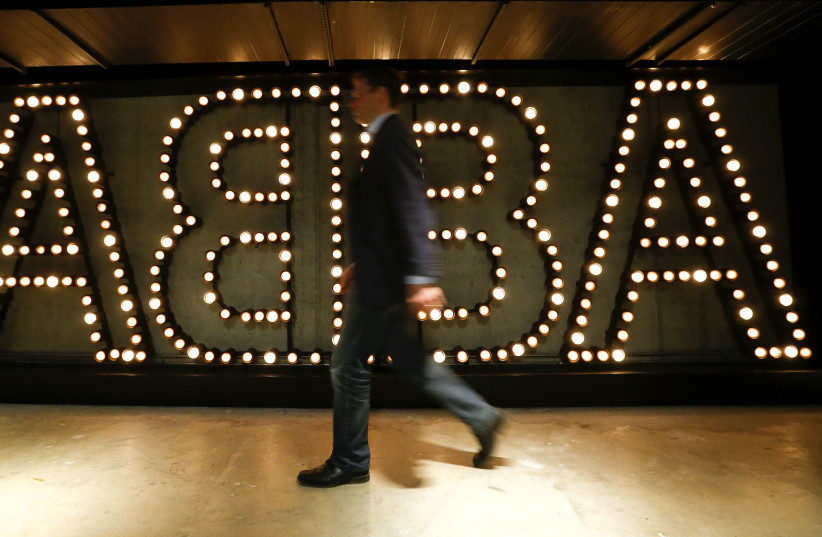  A man walks past the lit logo of the legendary Swedish pop group ABBA at ''ABBA - The Museum'' in Stockholm (credit: ARND WIEGMANN / REUTERS)