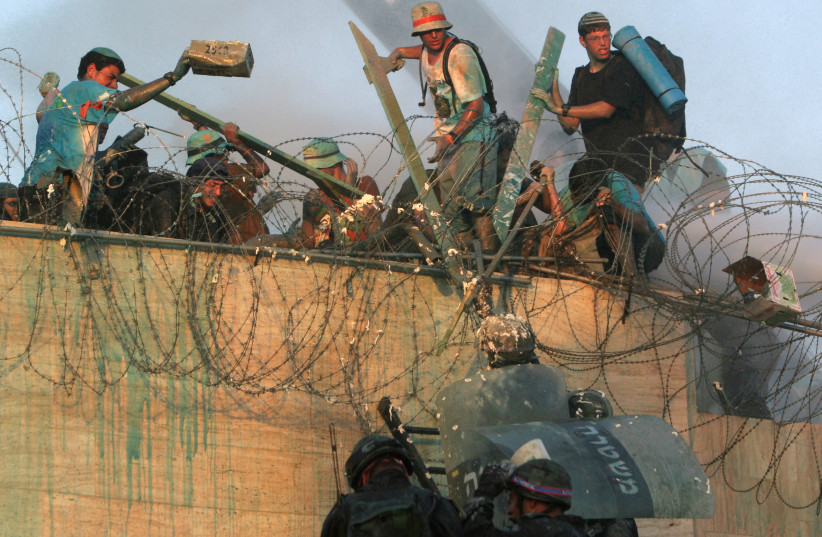  Opponents of Israel's disengagement plan try to prevent Israeli security forces from reaching the rooftop of a synagogue in the Jewish settlement of Kfar Darom, in the Gush Katif settlements bloc, southern Gaza Strip, August 18, 2005. (credit: PAUL HANNA/REUTERS)