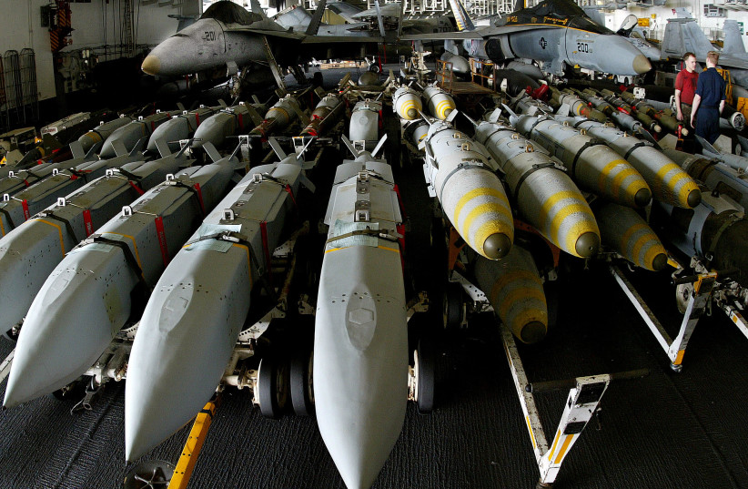  Ordenanzas de aviación junto a bombas guiadas por satélite JSOW (Joint Standoff Weapon) (izquierda) y JDAM (derecha) a bordo del portaaviones USS Kitty Hawk en el norte del Golfo el 9 de abril de 2003 (crédito: YVES HERMAN/REUTERS)