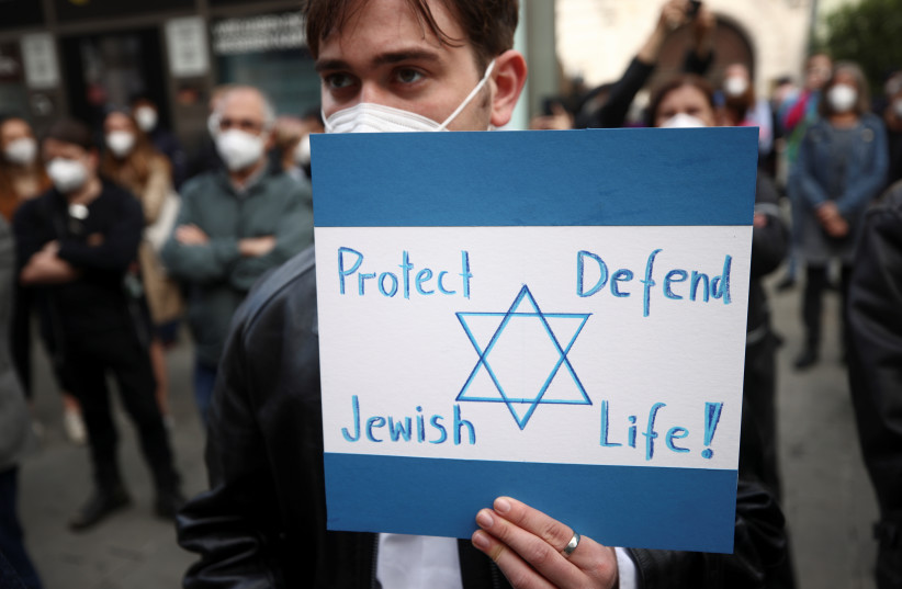  A pro-Israel demonstrator holds a placard during a protest following the violence between Israel and Palestinians, in Vienna, Austria, May 15, 2021.  (photo credit: REUTERS/LISI NIESNER)