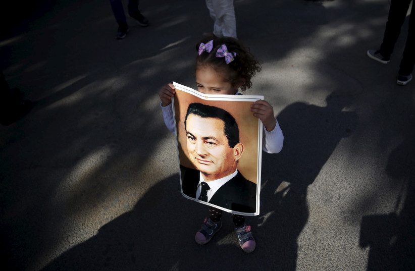  A supporter of ousted Egyptian president Hosni Mubarak holds a picture of him, outside the area where he is hospitalized, during a celebration of the 33rd anniversary of the liberation of Sinai in front of Maadi military hospital on the outskirts of Cairo, April 25, 2015. (credit: REUTERS/AMR ABDALLAH DALSH)