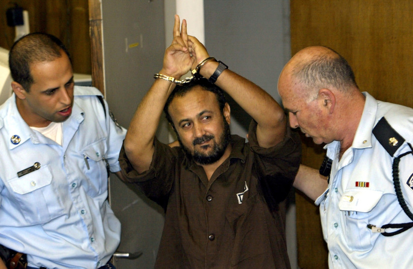  MARWAN BARGHOUTI gestures as  Israel Police bring him into Tel Aviv  District Court for a judgment hearing,  2004.  (credit: DAVID SILVERMAN / REUTERS)