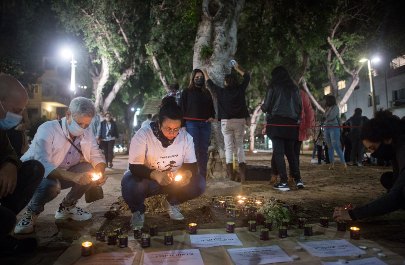  Israelis light candles in memory of women murdered in domestic violence, at a set up memorial on Rothschild Boulevard, ahead of International Day of Violence Against Women. November 24, 2020.  (photo credit: MIRIAM ALSTER/FLASH90)