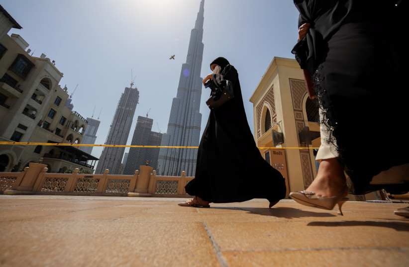 Women walk past the Burj Khalifa in Dubai, United Arab Emirates, June 11, 2021