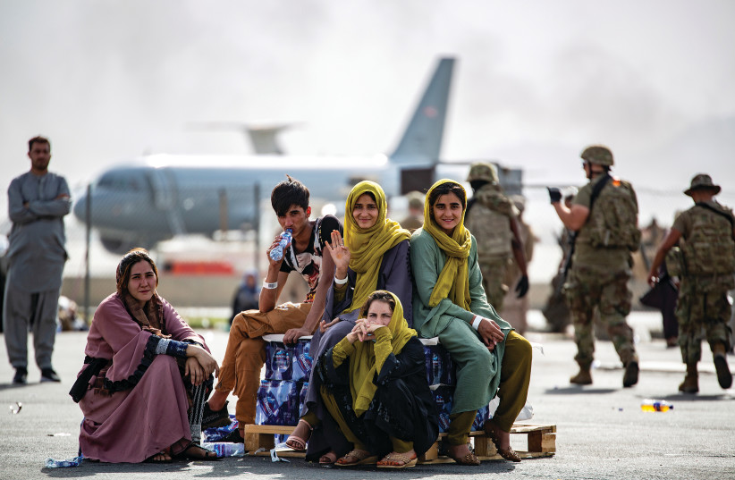 Evacuee children wait for a flight at Kabul’s airport in August amid the backdrop of the perception that the US’s Afghanistan withdrawal is having an impact across the Middle East. (credit: 1ST LT. MARK ANDRIES/US MARINE CORPS VIA REUTERS)