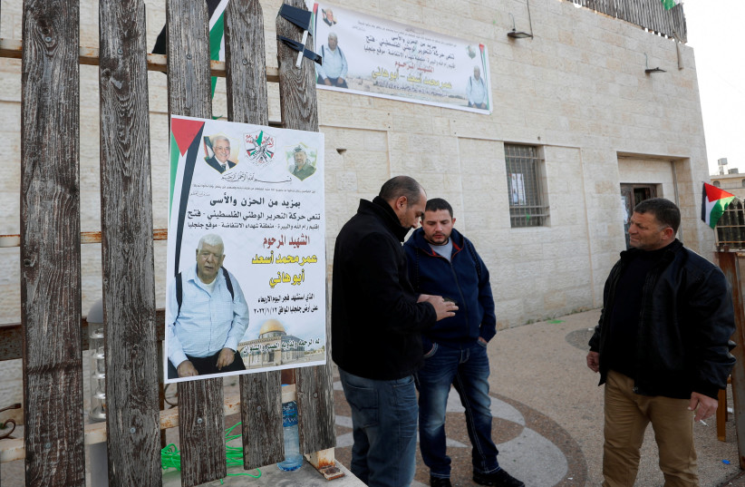  Men stand next to a poster of Palestinian Omar Abdalmajeed As'ad, 80, in Jiljilya village in the Israeli-occupied West Bank January 12, 2022. (credit: MOHAMAD TOROKMAN/REUTERS)